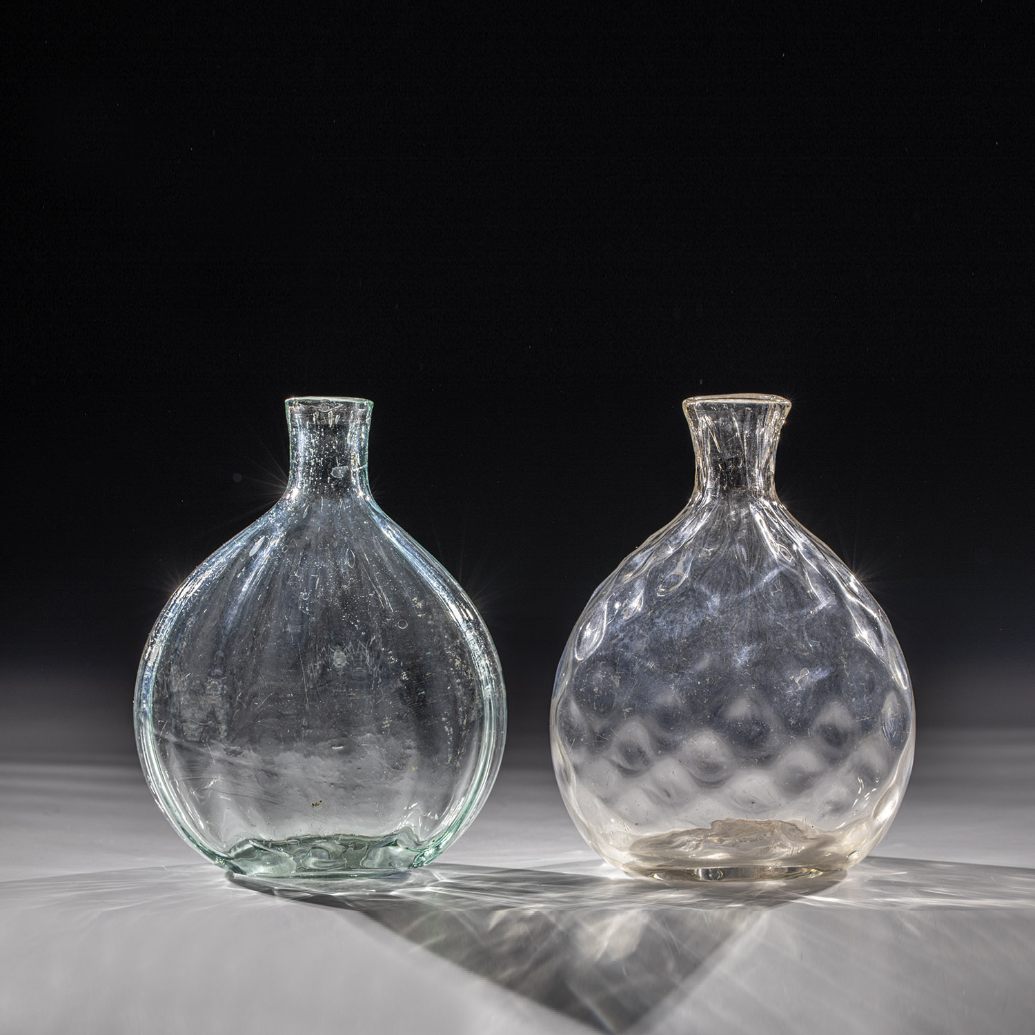Two pouch bottles Alpine, 18th century Colourless glass with tear and slightly raised bottom.