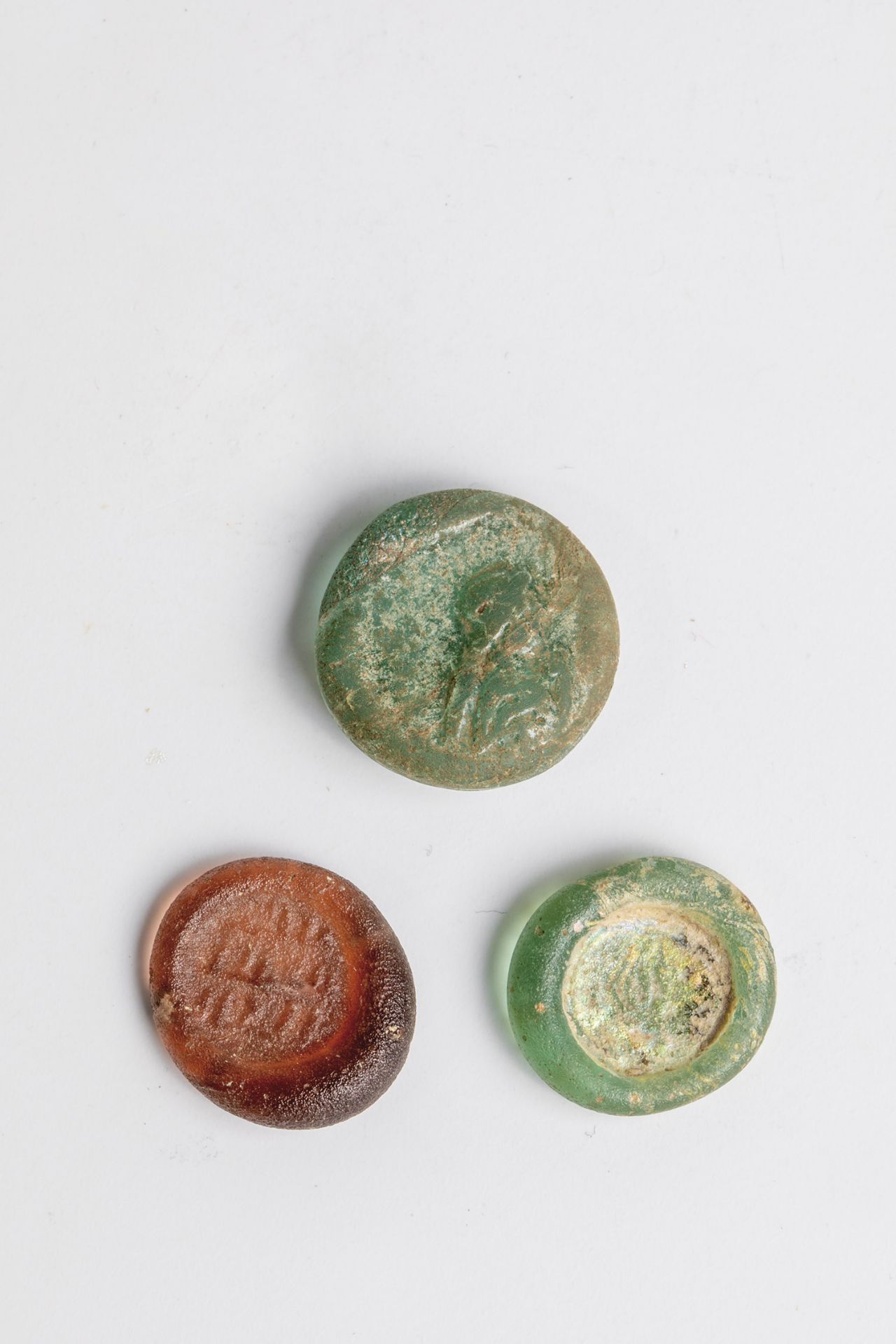 Three coins made of glass Eastern Mediterranean, 1st-4th century AD. Light green or violet glass,