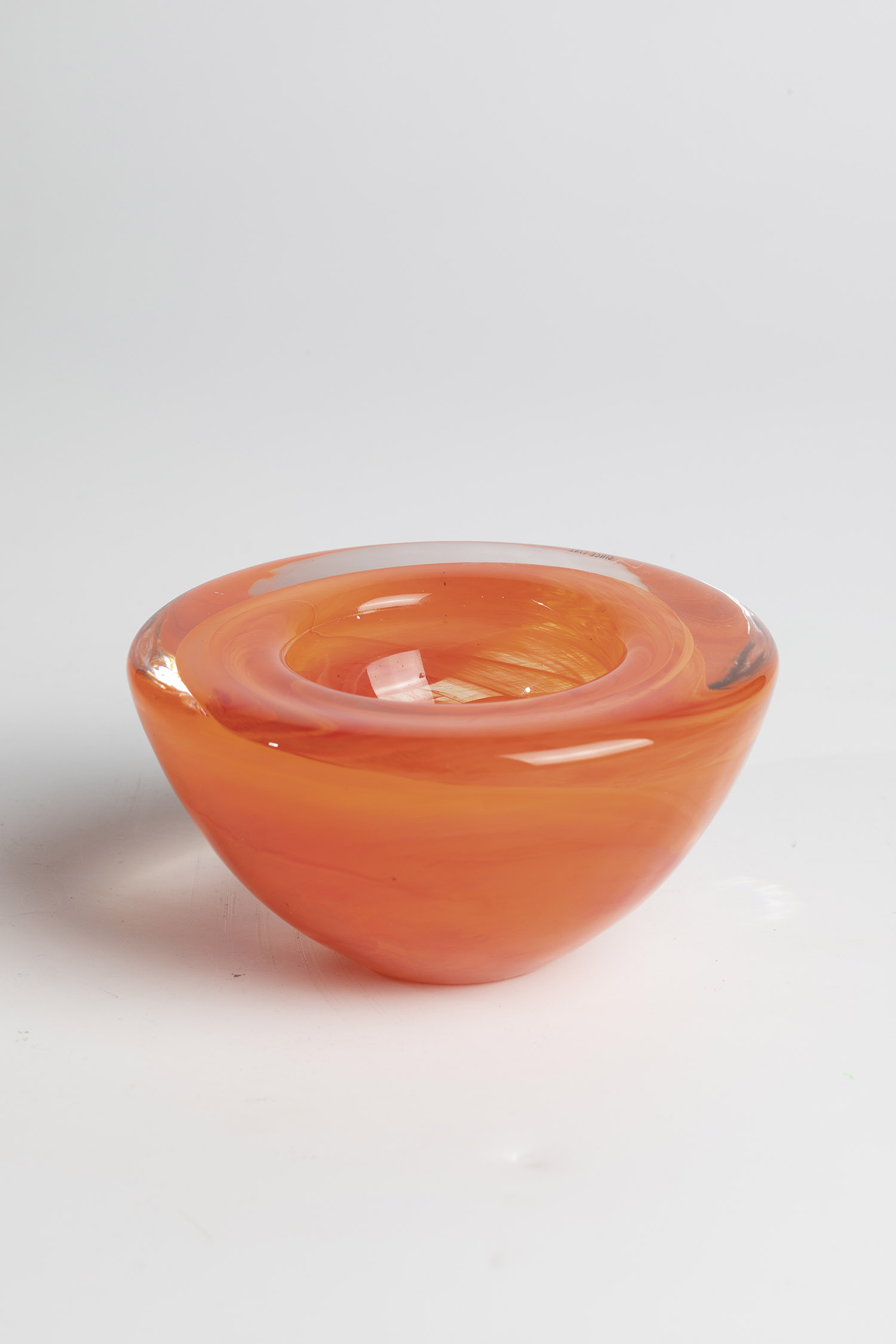 Small bowl Kosta Boda, thick-walled, colorless glass with orange interlayer decoration. Underside