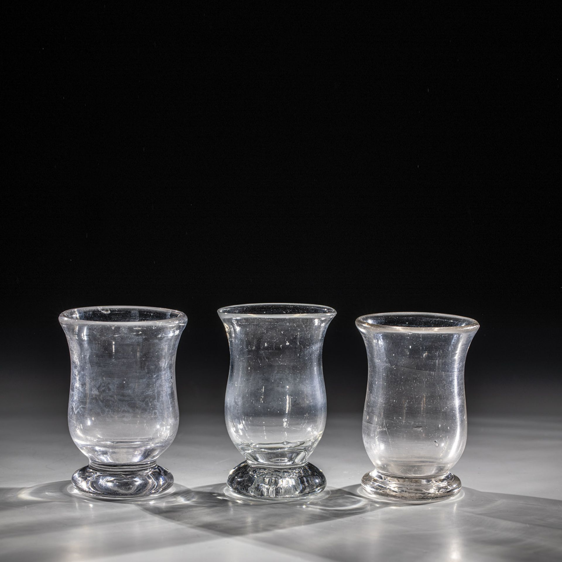 Three drinking glasses Germany, 19th century Colourless glass with tear-off. One lip margin min.