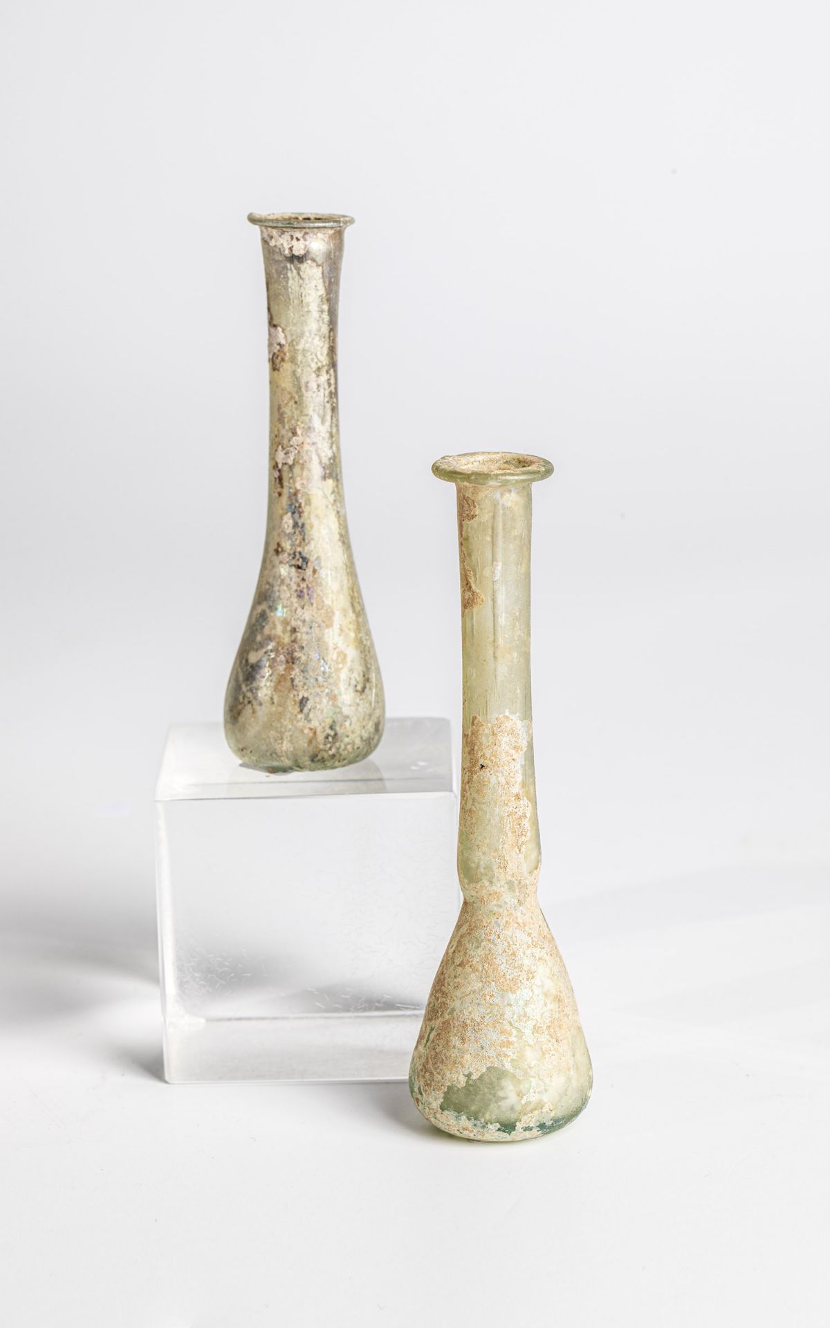Two vials from the Eastern Mediterranean, 2nd-3rd century. Greenish glass. Mouth protruding. H. 9.