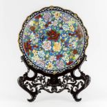 A large Chinese Cloisonné plate in an openworked sculptured wood stand. (W:51 x H:67 cm)