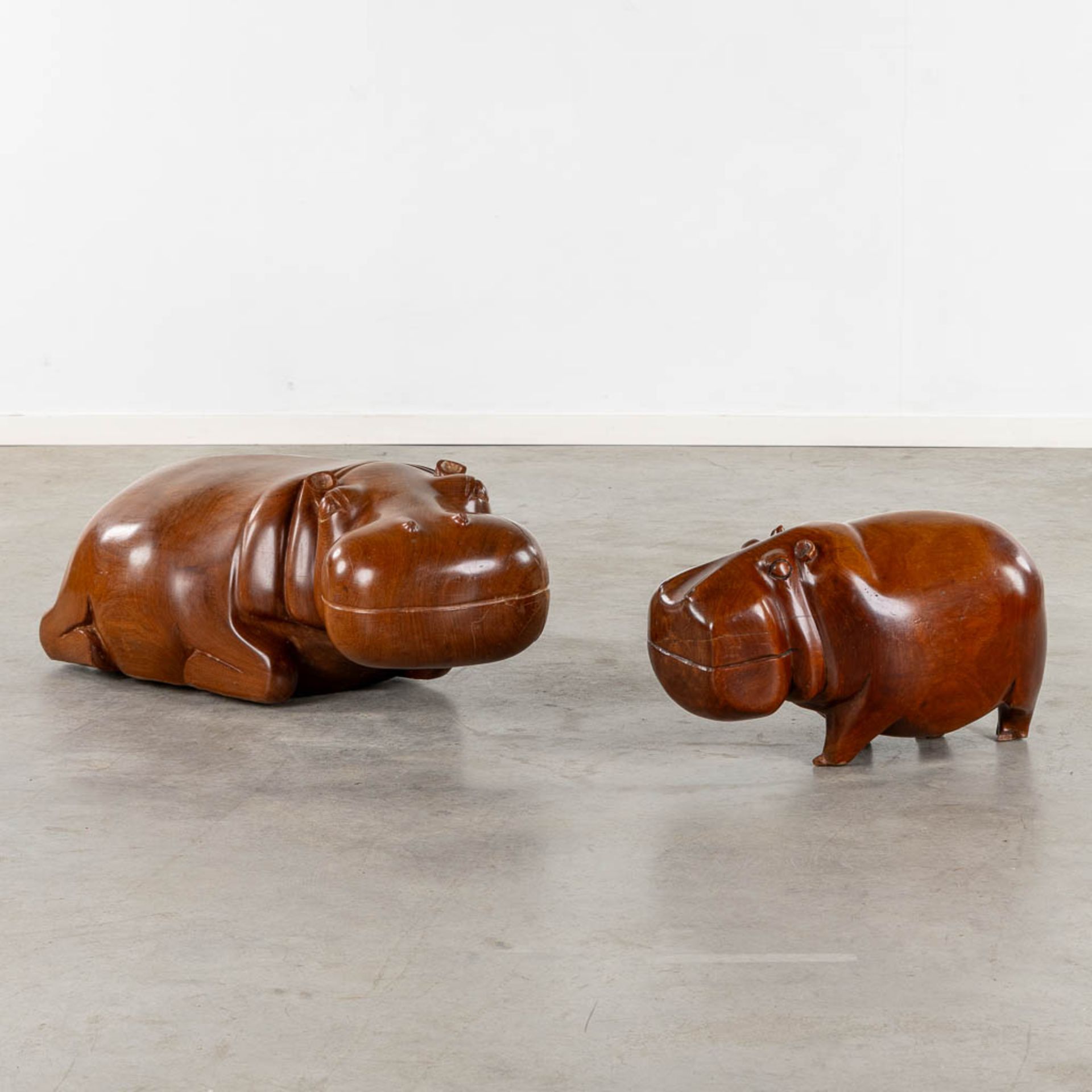 Two benches in the shape of a hippo, sculptured mahogany. (L:50 x W:94 x H:35 cm)