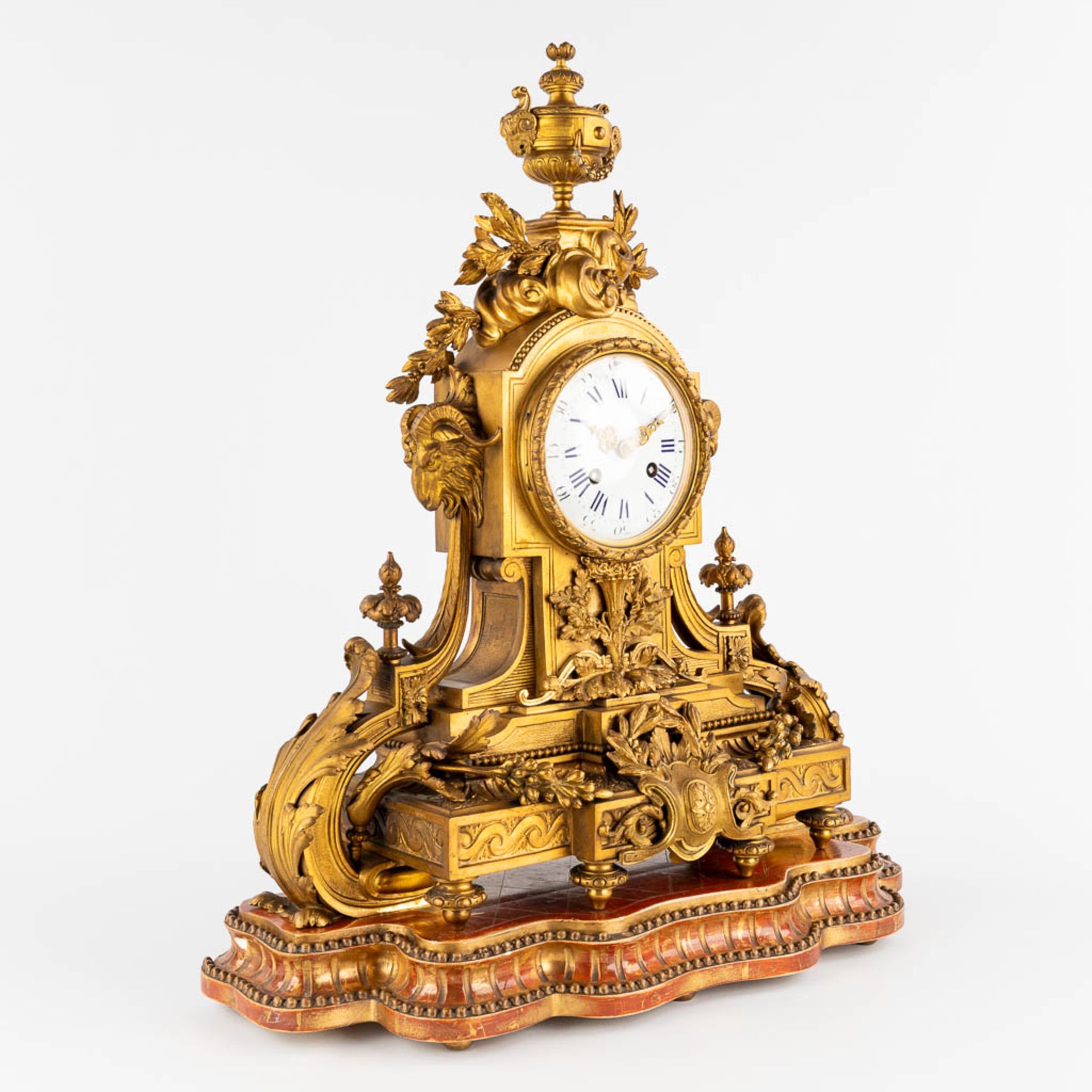 An antique mantle clock, gilt bronze in a Louis XVI style, decorated with ram's heads. Circa 1880. ( - Image 4 of 18