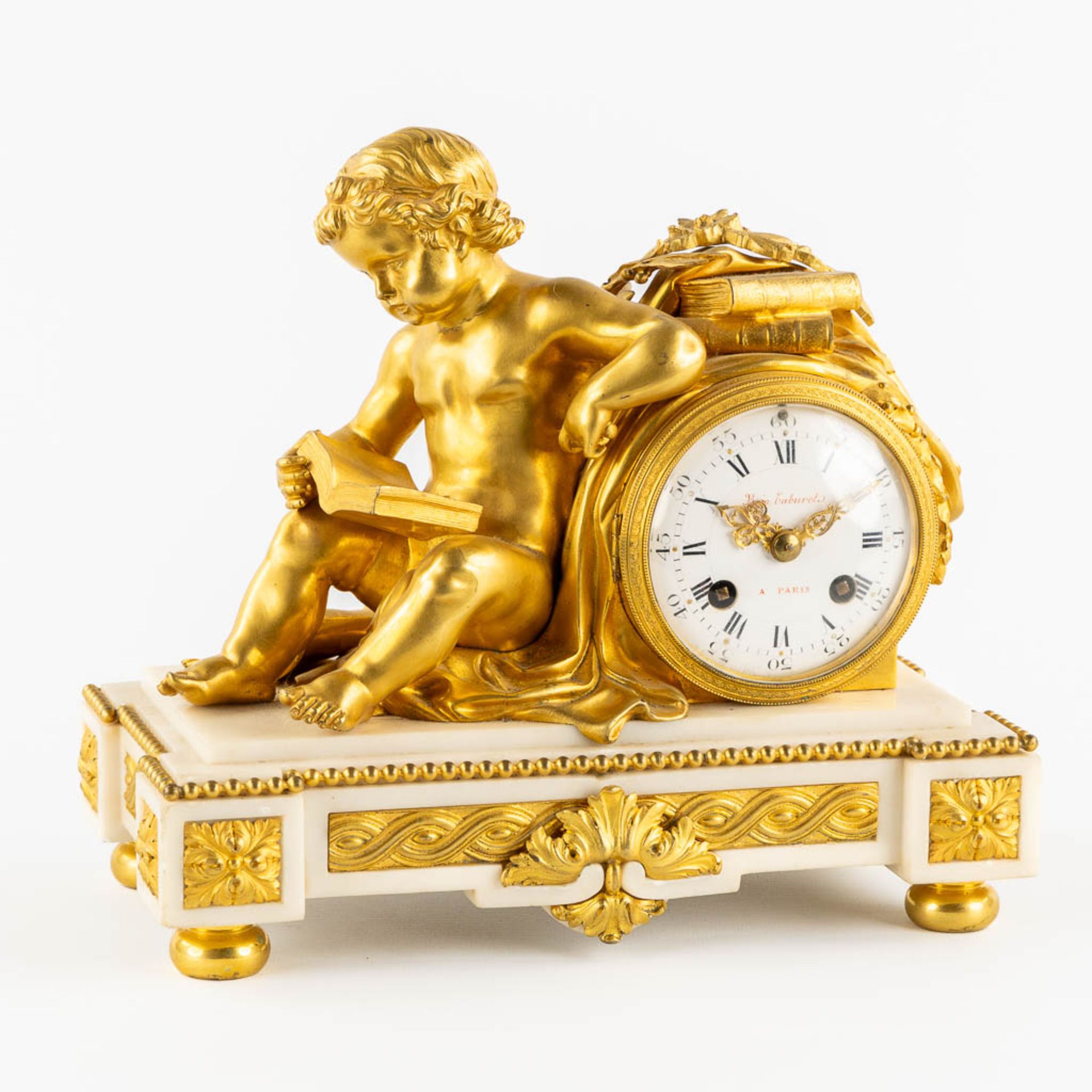 A mantle clock with a putti figurine, gilt bronze on white Carrara marble. 19th C. (L:15 x W:27 x H: