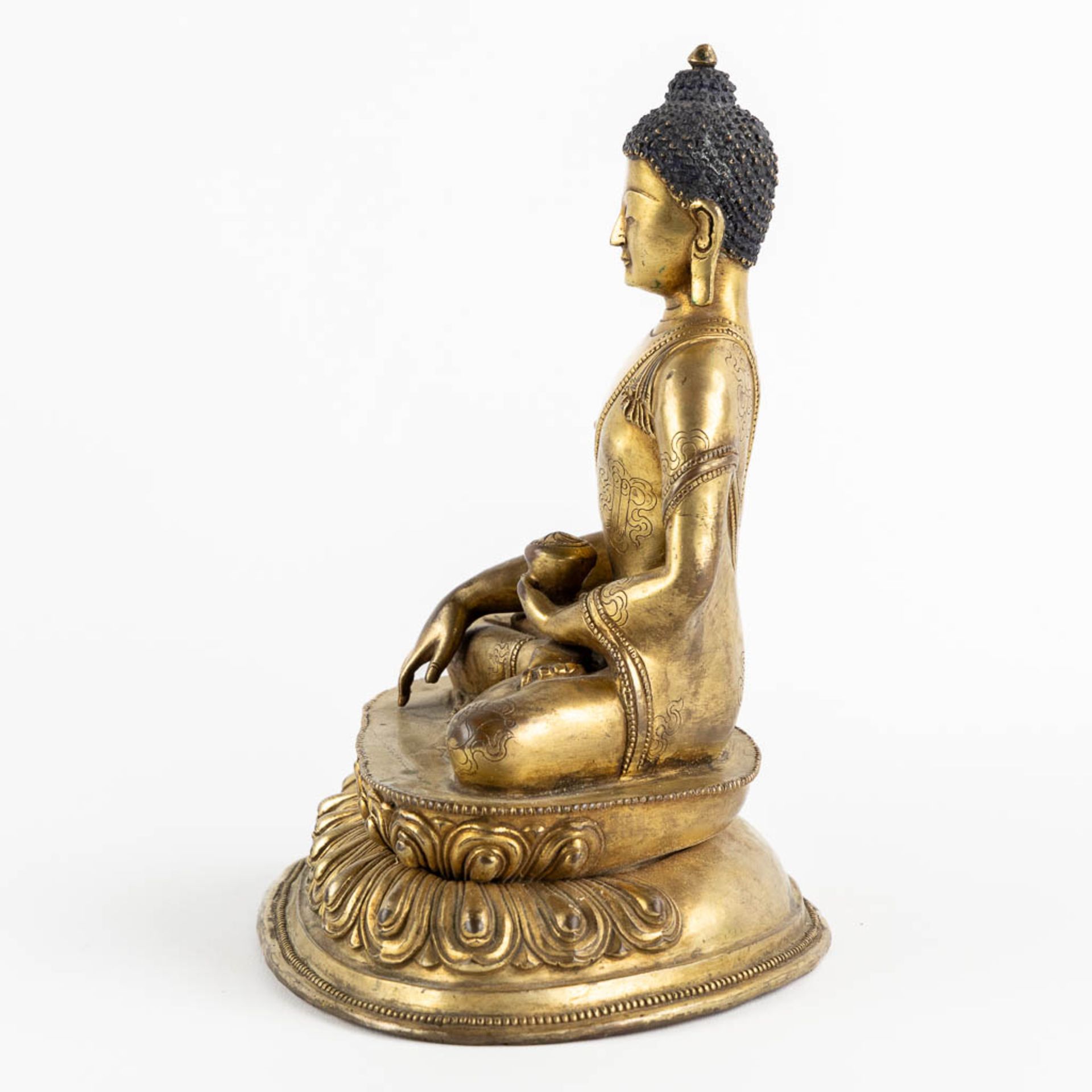 A seated buddha figurine, on a lotus flower. Gilt bronze. (L:15 x W:19 x H:22 cm) - Bild 6 aus 10