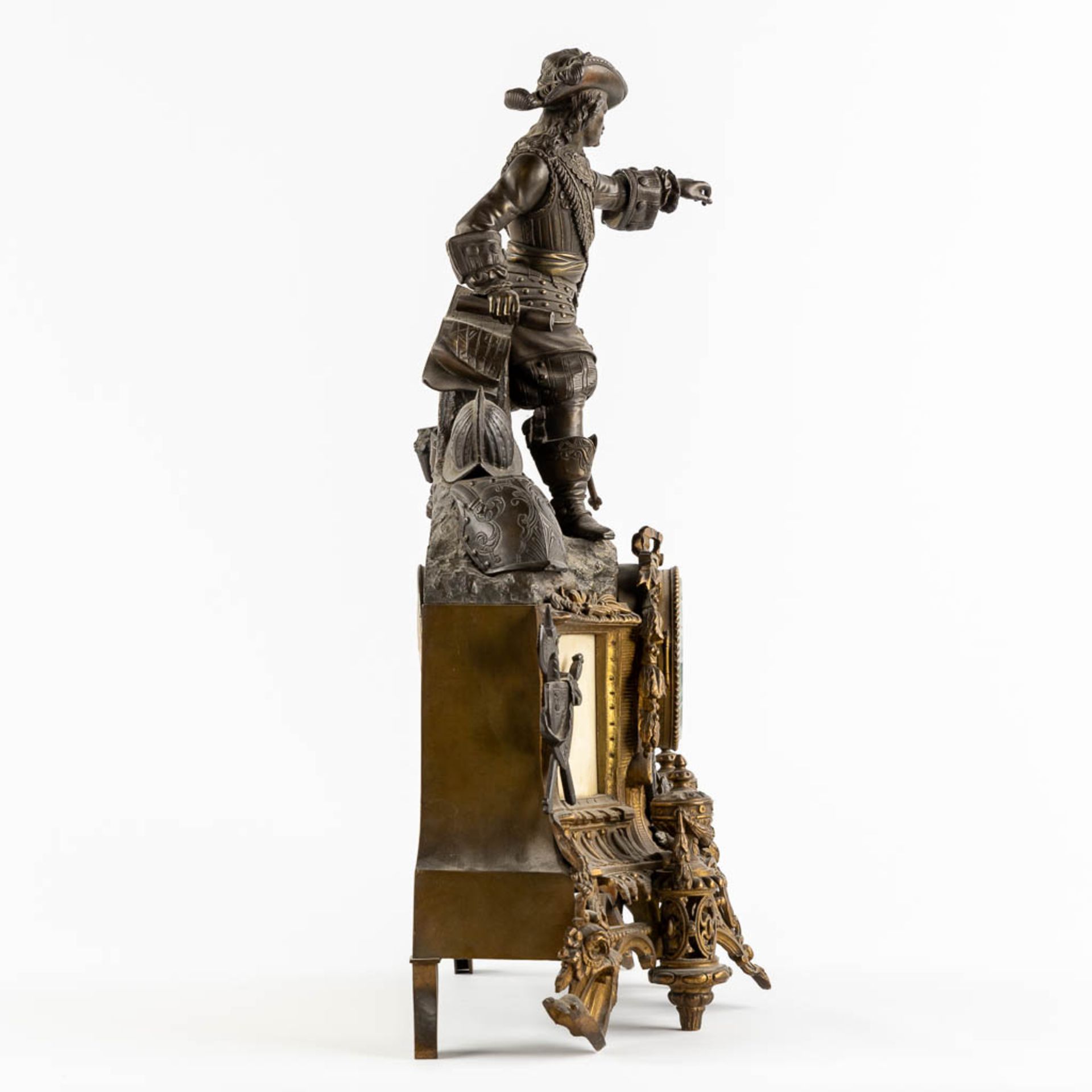 A mantle clock with a musketeer, patinated and gilt bronze on Carrara marble. 19th C. (L:17 x W:45 x - Bild 6 aus 12