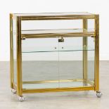 A small, rolling display cabinet. Gilt metal and glass. Circa 1980. (L:44 x W:80 x H:81 cm)