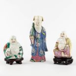 Three polychrome porcelain figurines of Buddha and Lao Tse. (L:7 x W:10 x H:24 cm)