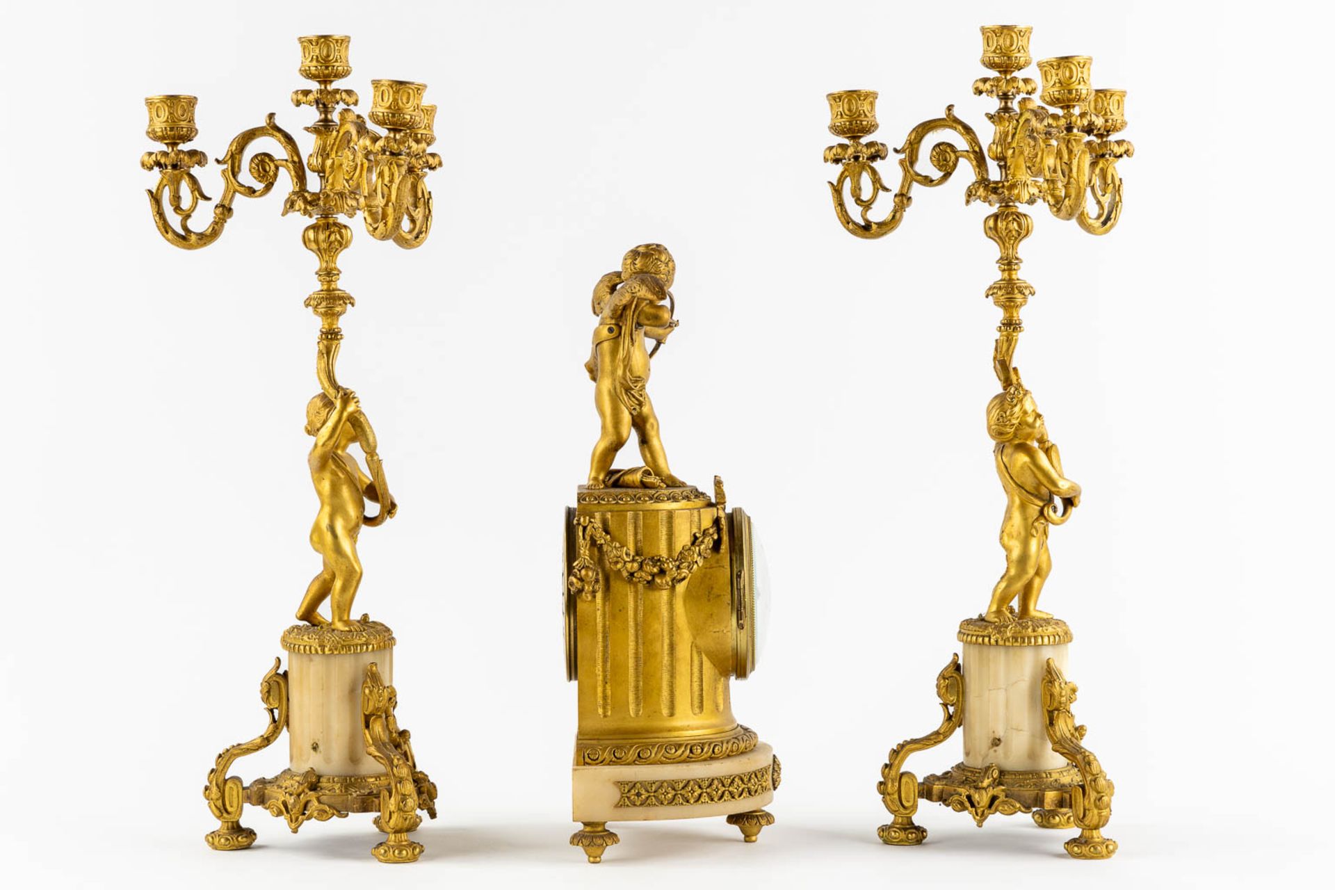 A three-piece Neoclassical mantle garniture, clock with candelabra, Cupid and Putti. 19th C. (L:13 x - Bild 4 aus 13