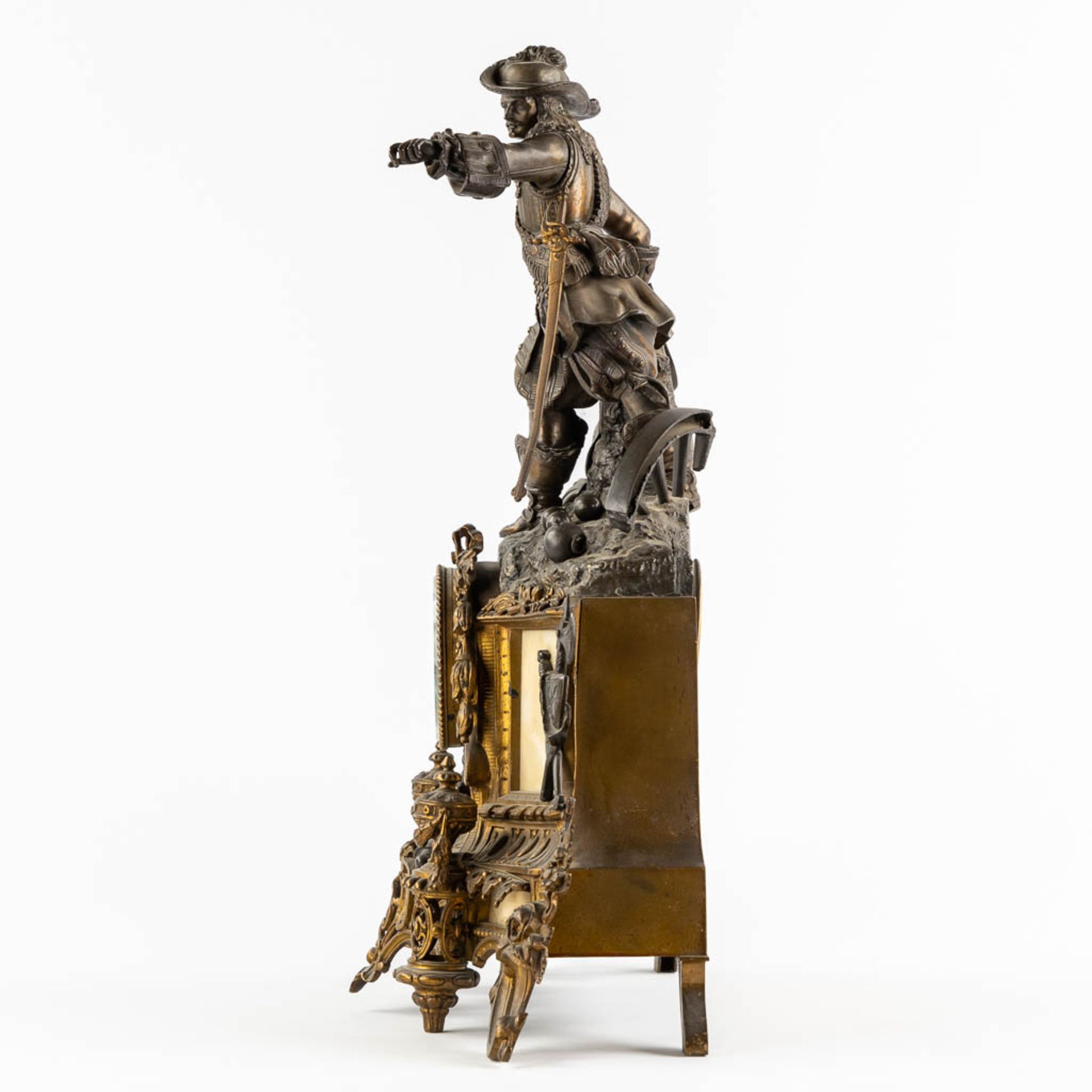 A mantle clock with a musketeer, patinated and gilt bronze on Carrara marble. 19th C. (L:17 x W:45 x - Bild 4 aus 12