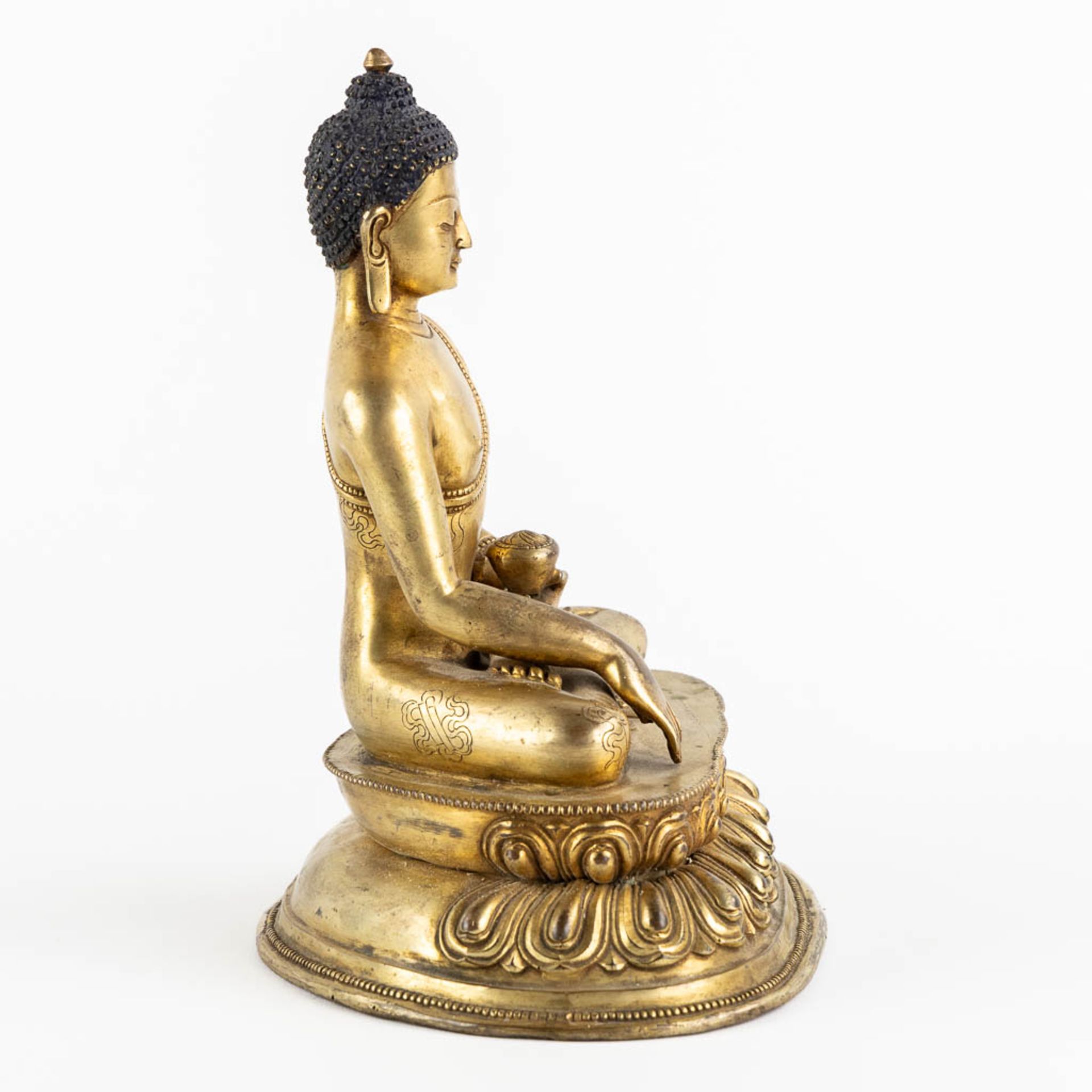 A seated buddha figurine, on a lotus flower. Gilt bronze. (L:15 x W:19 x H:22 cm) - Bild 4 aus 10