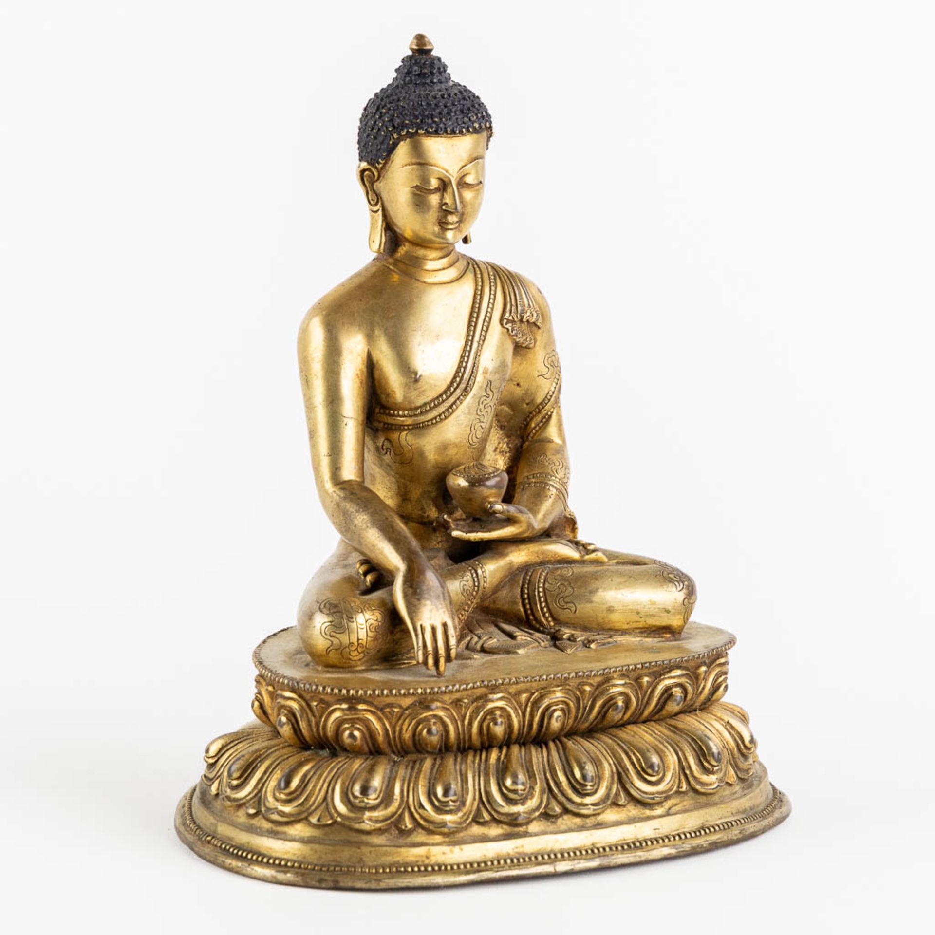 A seated buddha figurine, on a lotus flower. Gilt bronze. (L:15 x W:19 x H:22 cm) - Bild 3 aus 10
