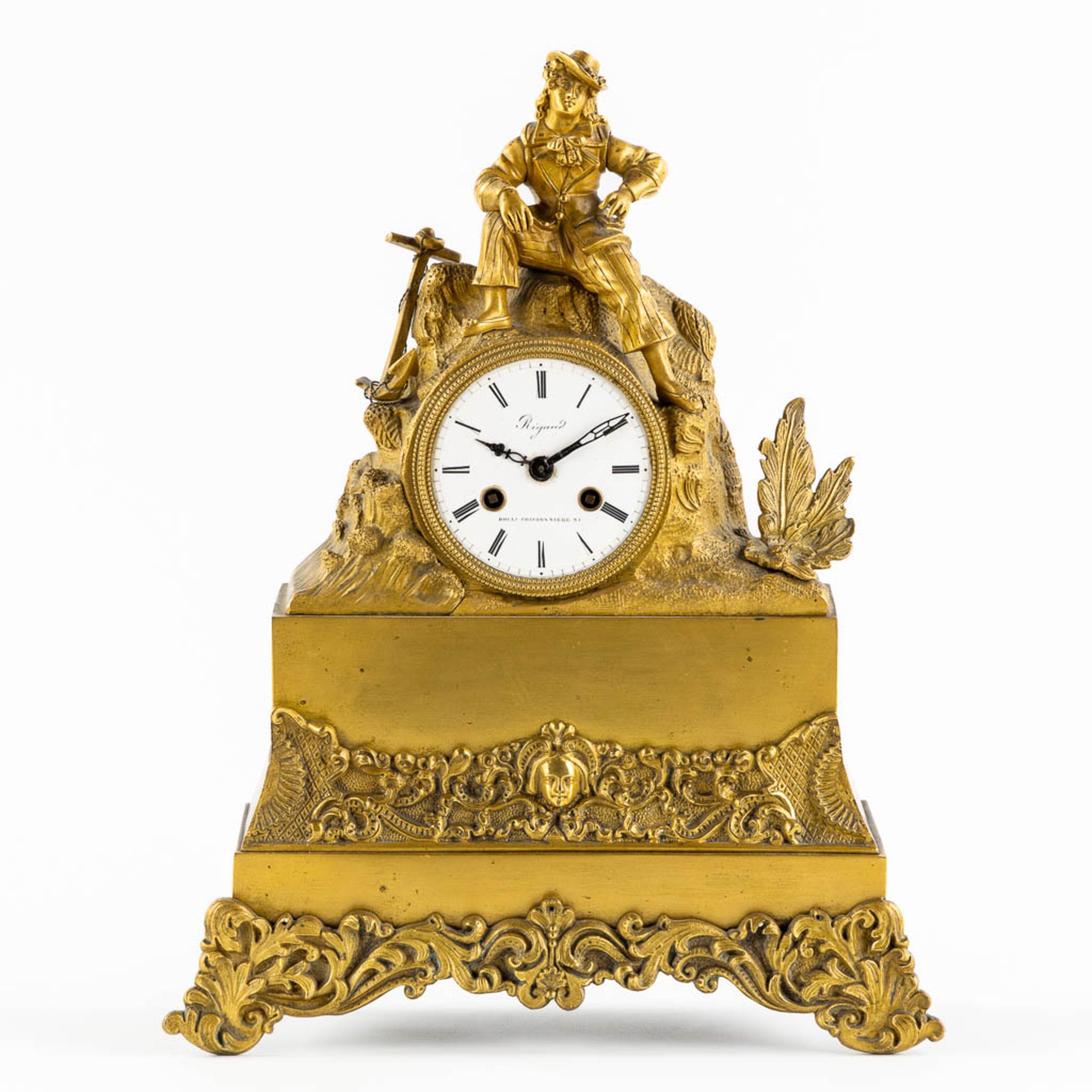 A mantle clock, gilt bronze with an image of a young man. France, 19th C. (L:10 x W:27 x H:35 cm)