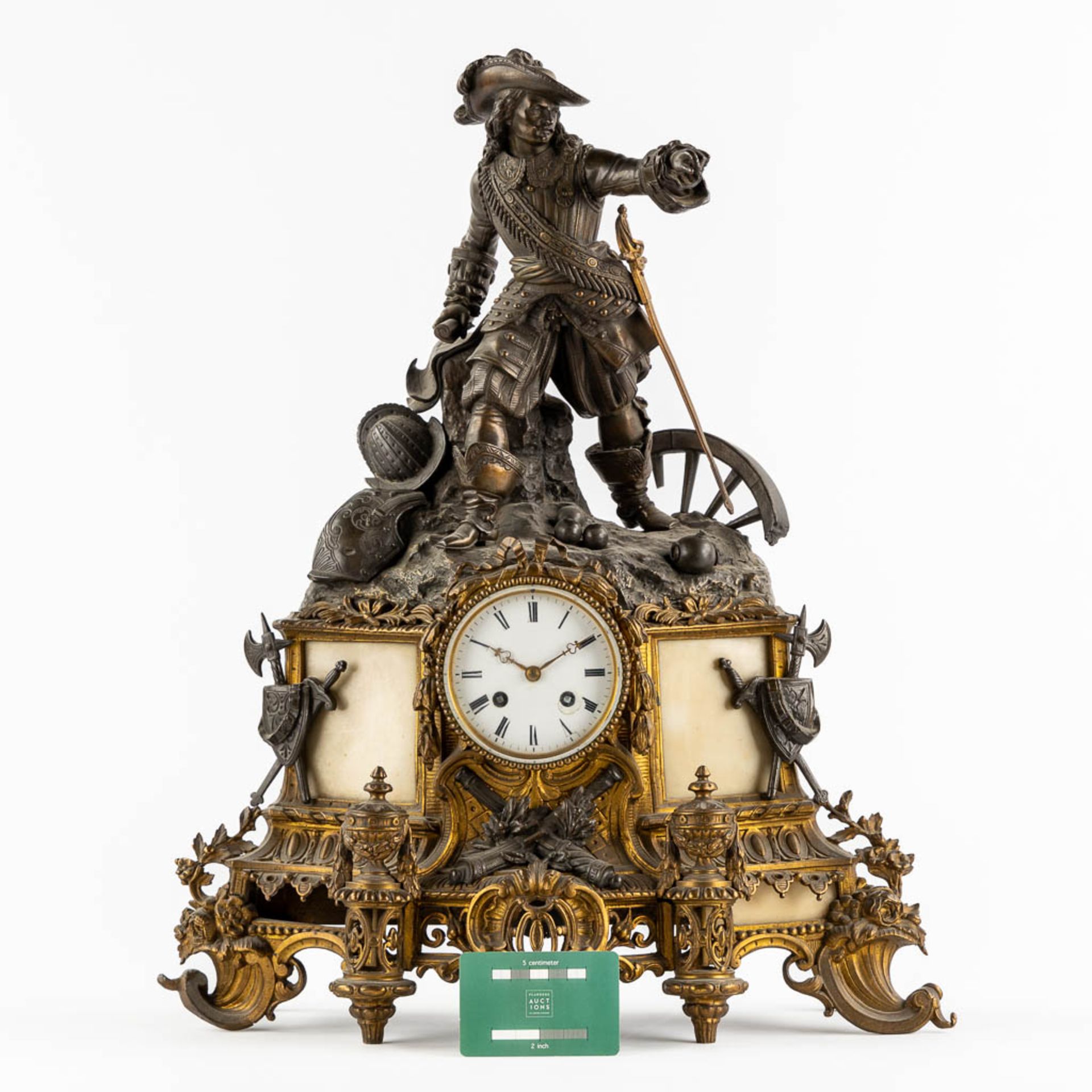 A mantle clock with a musketeer, patinated and gilt bronze on Carrara marble. 19th C. (L:17 x W:45 x - Bild 2 aus 12