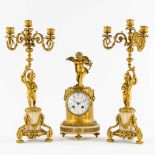 A three-piece Neoclassical mantle garniture, clock with candelabra, Cupid and Putti. 19th C. (L:13 x