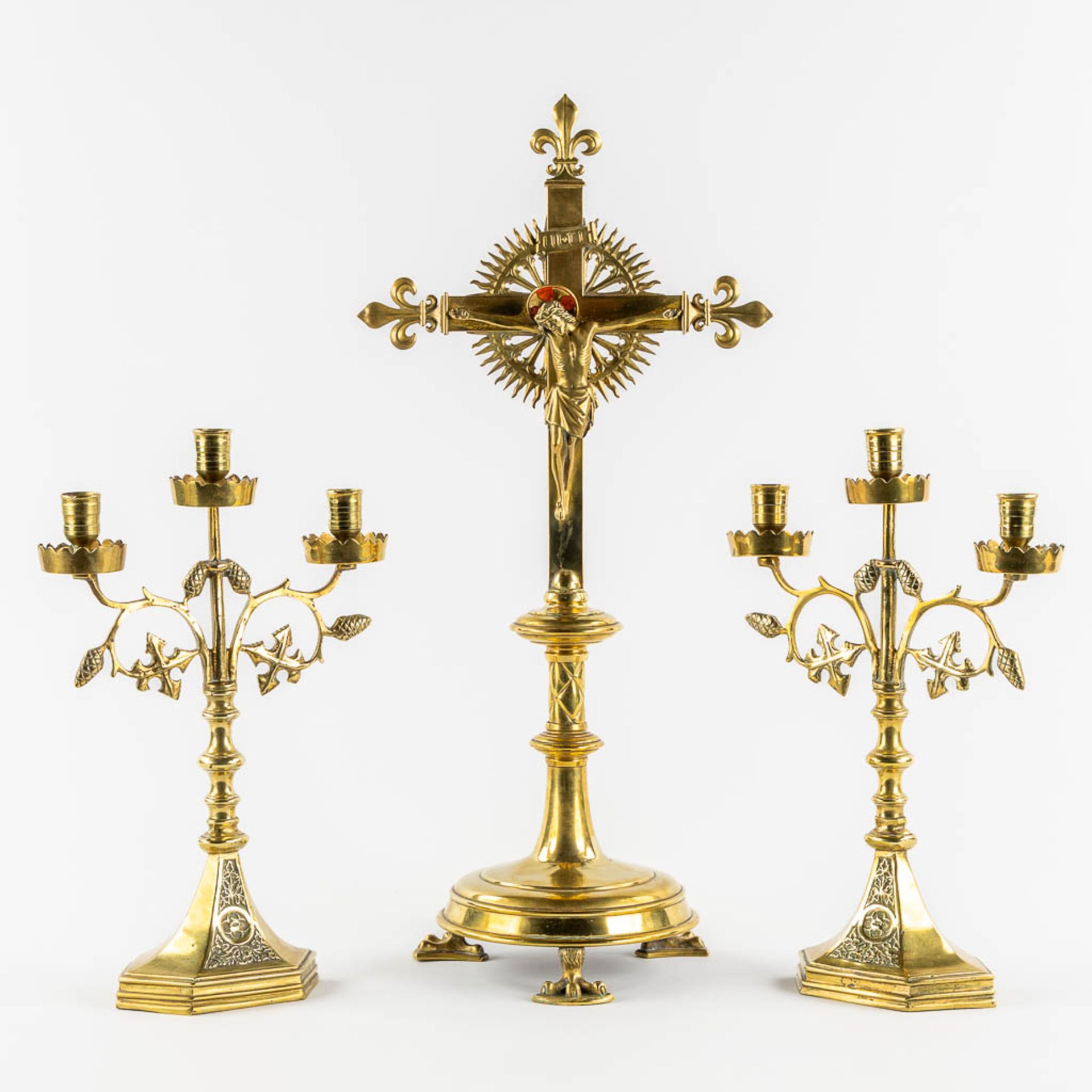 An altar crucifix with two matching candelabra. Gilt brass. Gothic Revival. (L:20 x W:29 x H:60 cm)