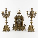 A three-piece mantle garniture clock and candelabra, patinated bronze. (L:16 x W:33 x H:50 cm)