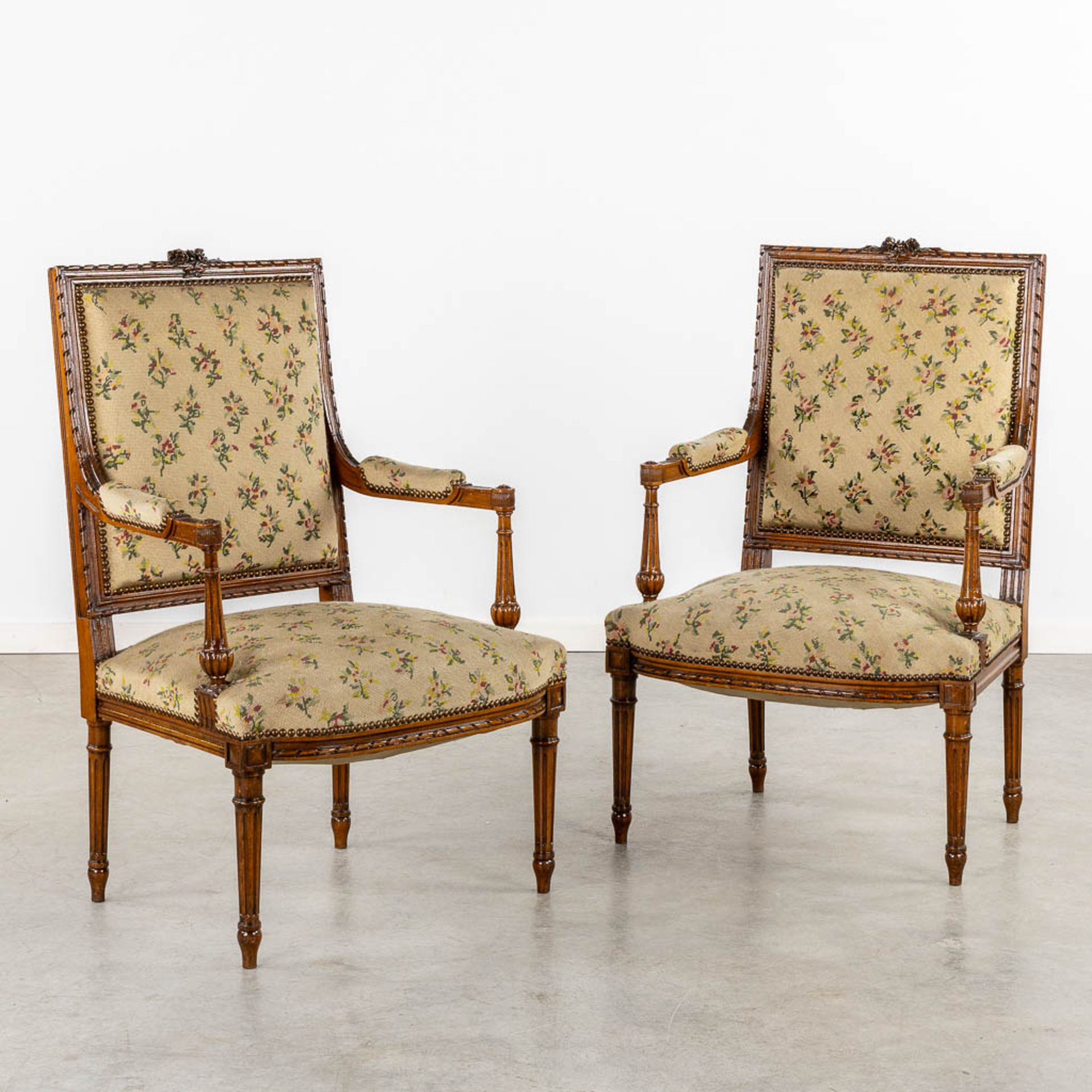 A pair of wood-sculptured armchairs with emboidered upholstry. Louis XVI style. (L:62 x W:64 x H:100