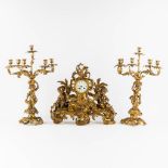 A three-piece mantle garniture clock and candelabra, gilt bronze. 19th C. (L:21 x W:55 x H:48 cm)