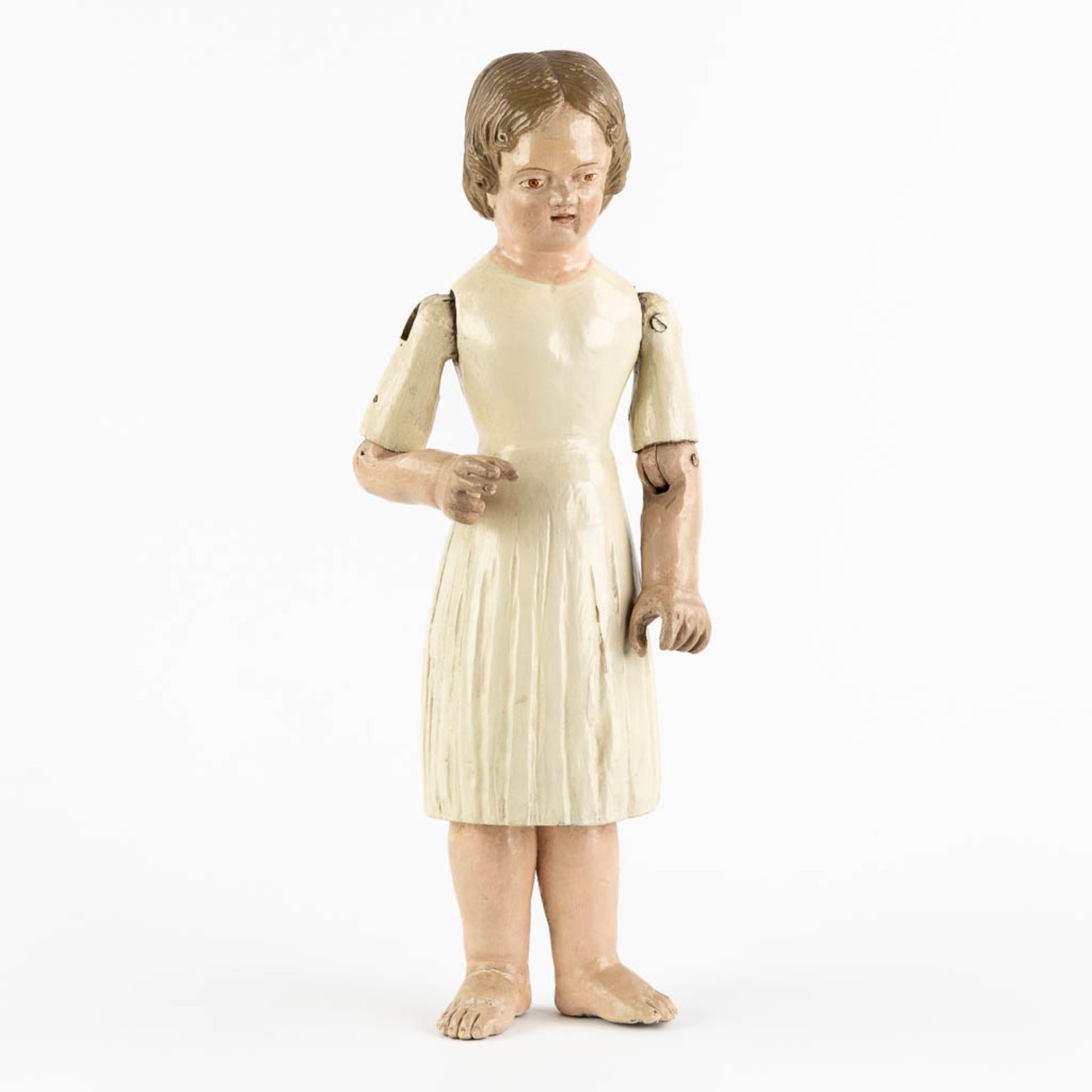 An antique patinated and wood-sculptured doll. 19th C. (L:11,5 x W:17 x H:45 cm)