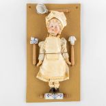 William Goebel, 'Boy Chef' a porcelain doll mounted on a cardboard with accessories. (W:20,5 x H:37