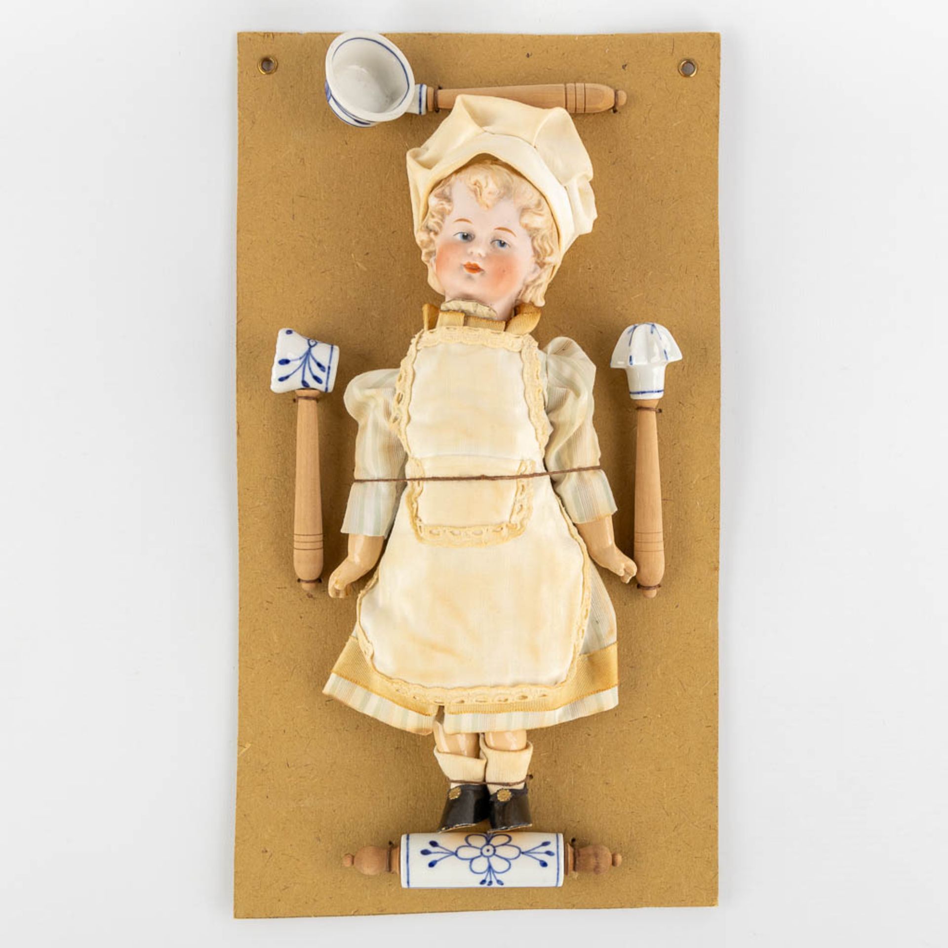 William Goebel, 'Boy Chef' a porcelain doll mounted on a cardboard with accessories. (W:20,5 x H:37 