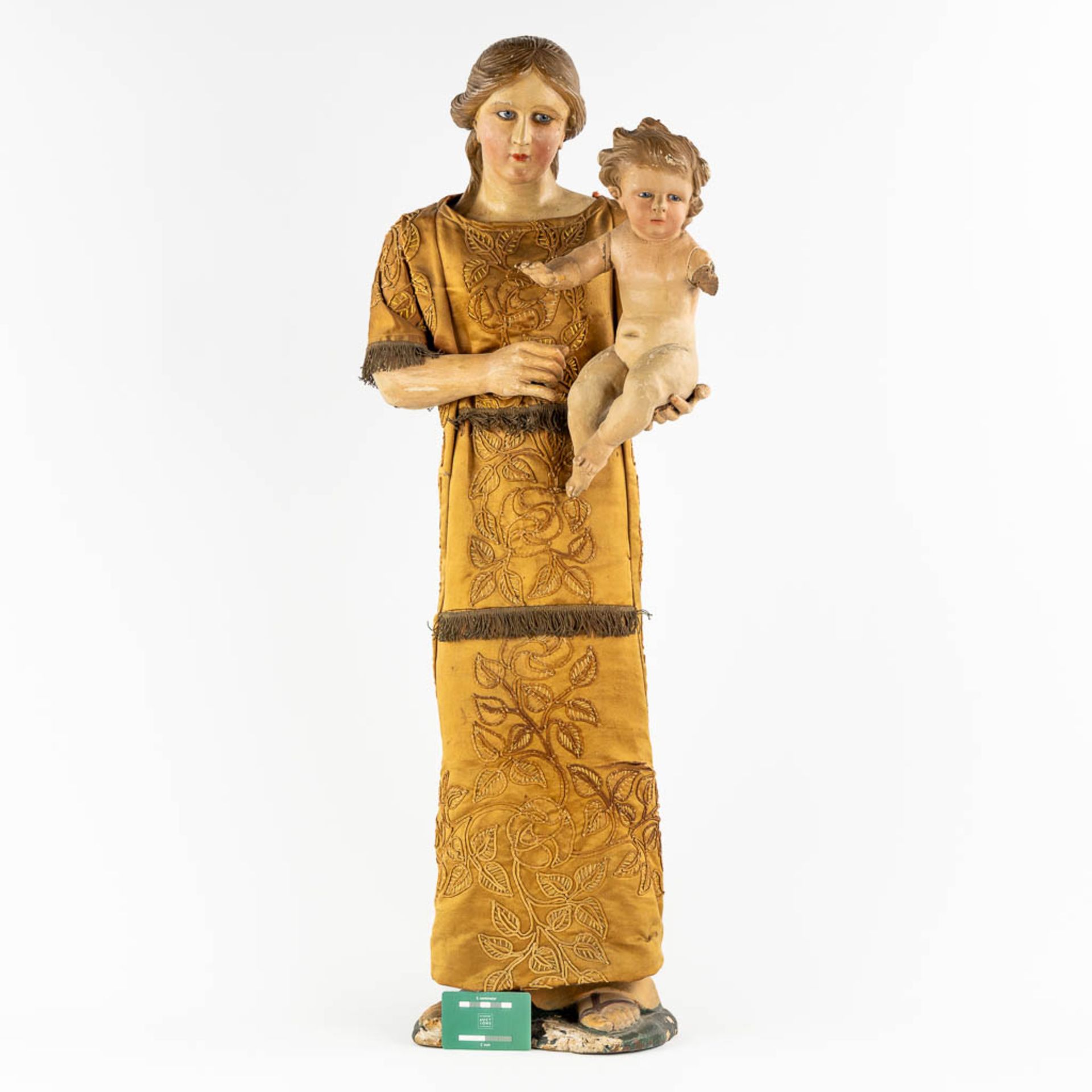 An antique sculptured figurine of a mother with child, wearing an embroidered robe. 19th C. (W:36 x - Image 2 of 15