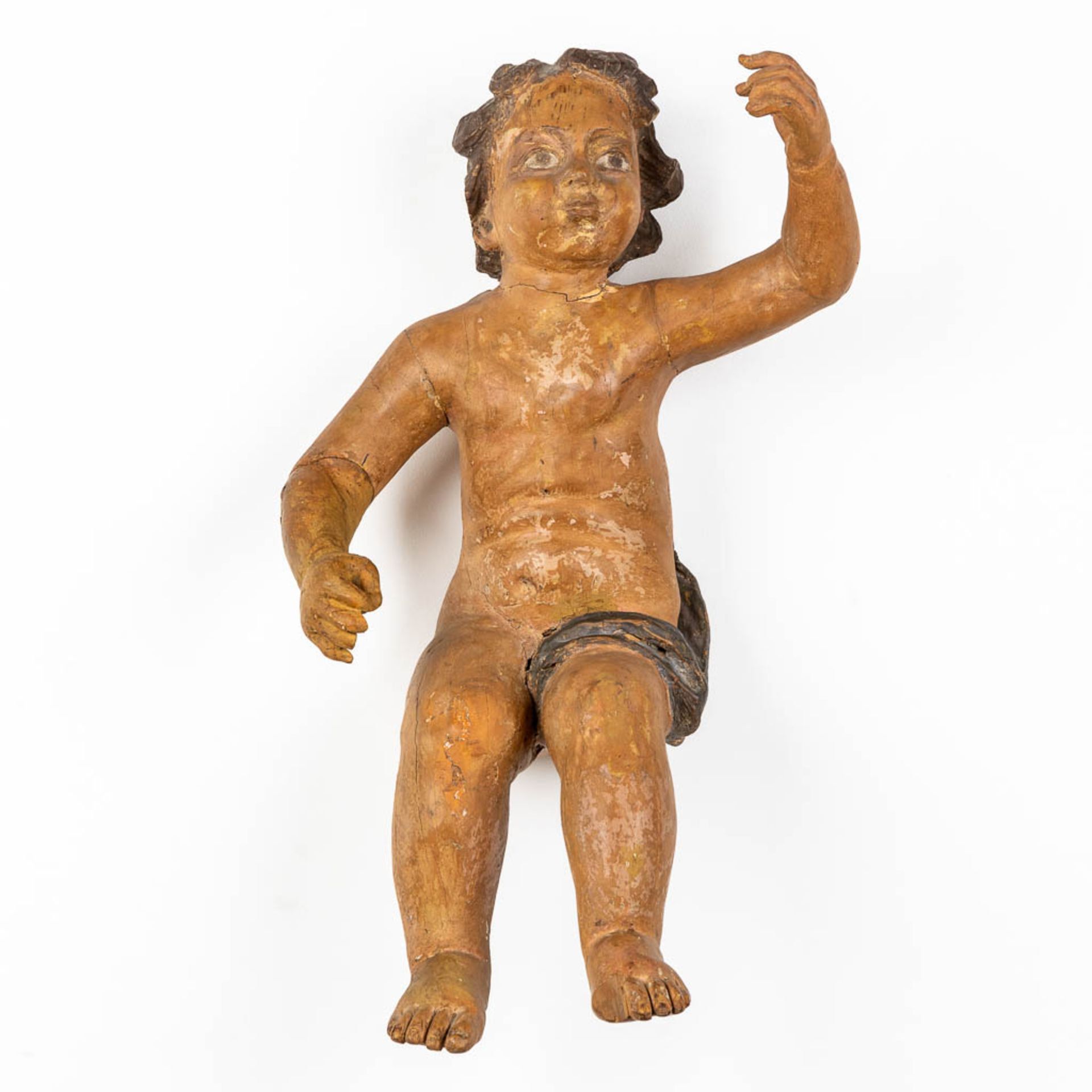 An antique figurine of a putto, sculptured and patinated wood. 18th C. (L:35 x W:34 x H:67 cm)