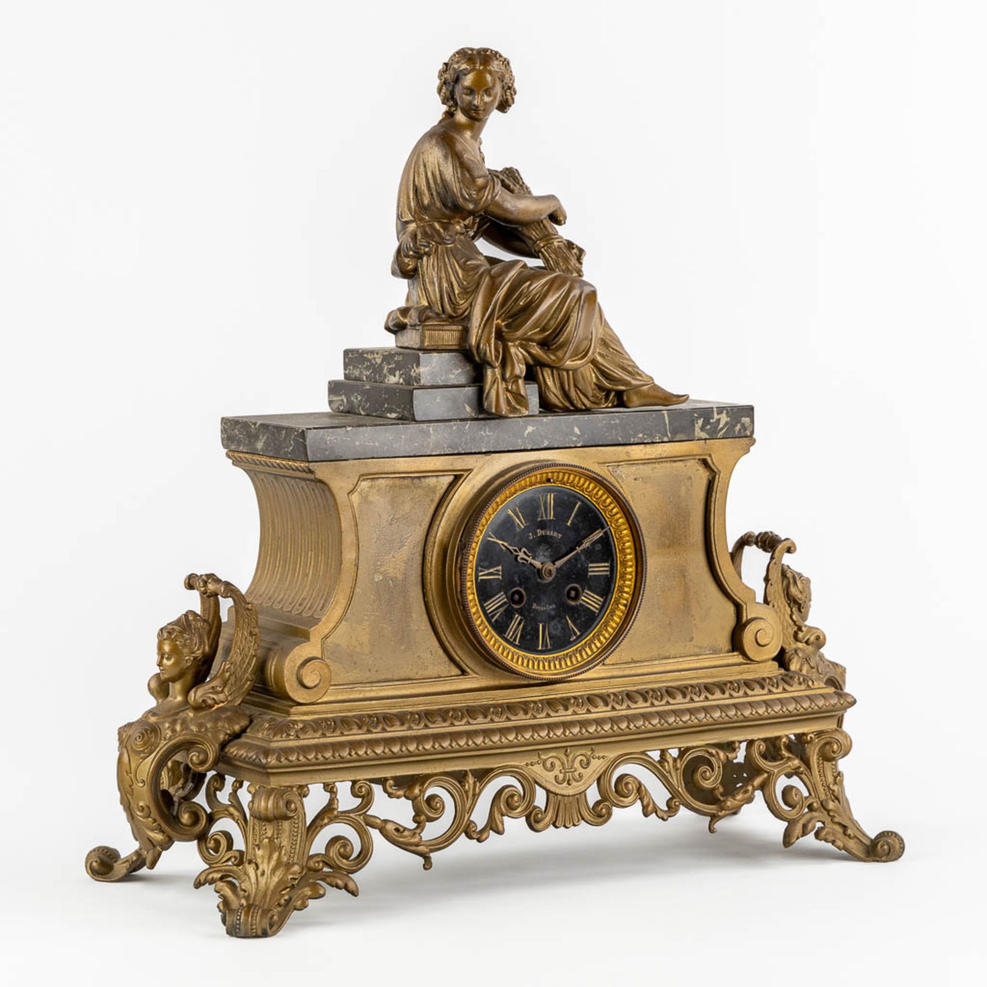 J. Dusart Bruxelles, A mantle clock. Gilt spelter and marble. Circa 1900. (L:20 x W:47 x H:46 cm)