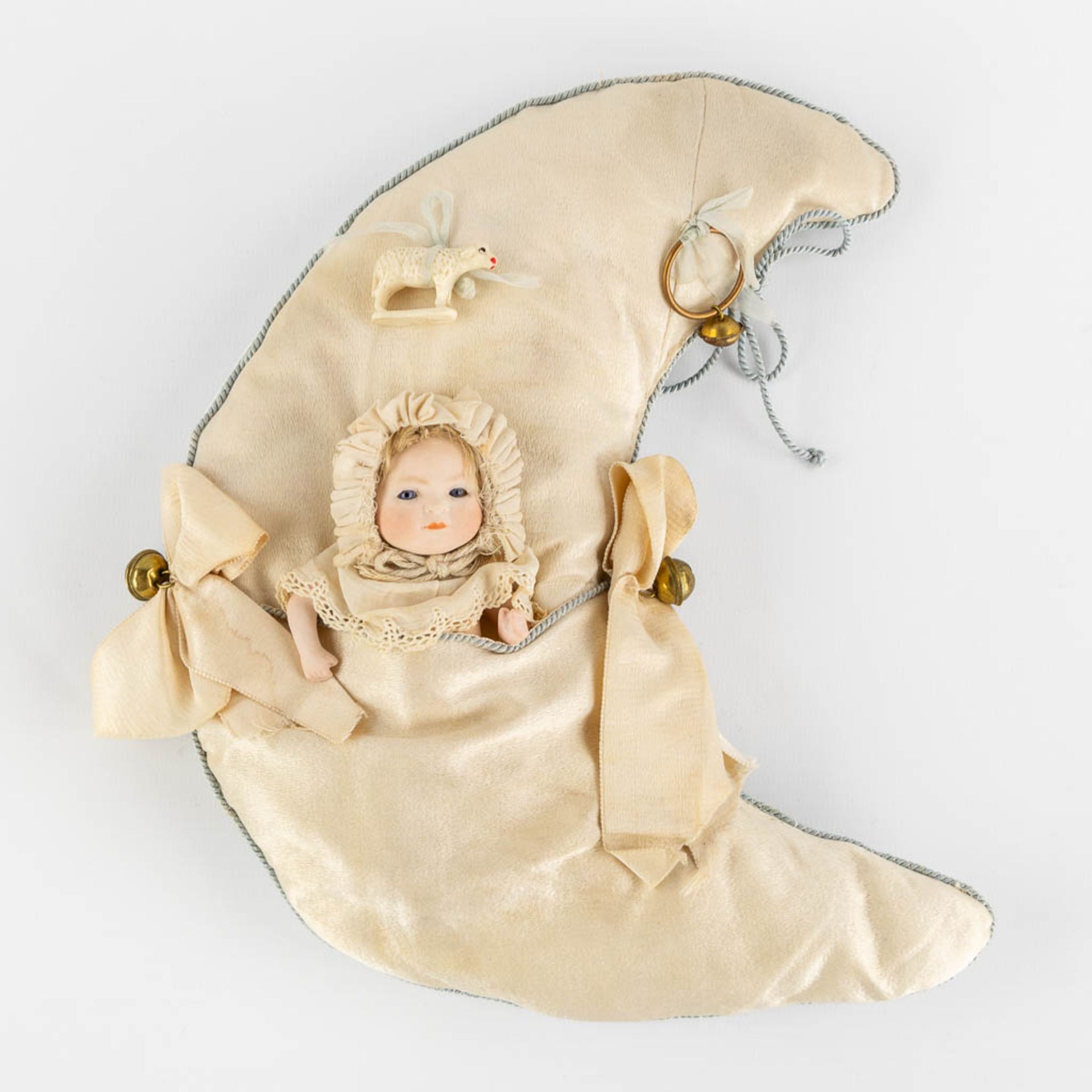 An antique doll in a crescent moon-shaped sleeping bag. Putnam 1922. (W:23 x H:26 cm)