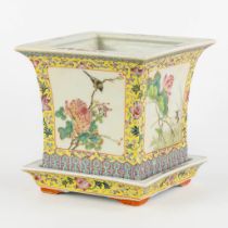 A Chinese Cache Pot, Famille Rose decorated with fauna and flora. (L:18 x W:18 x H:17,5 cm)