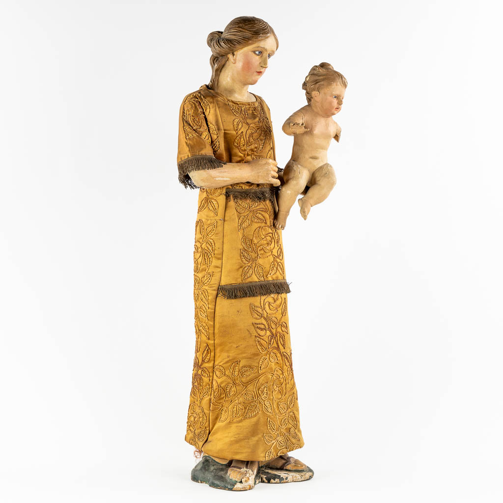 An antique sculptured figurine of a mother with child, wearing an embroidered robe. 19th C. (W:36 x - Image 3 of 15