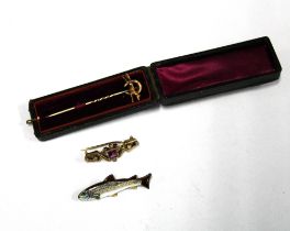 15ct gold fox hunting stick pin, an enamel fish brooch and a yellow metal gem set brooch (3)