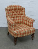 Upholstered buttonback armchair with mahogany legs and brass castors, 76 x 97 x 55cm.