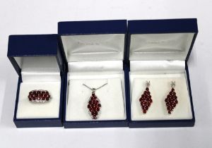 9ct white gold parure comprising a ruby and diamond dress ring, drop earrings and pendant necklace