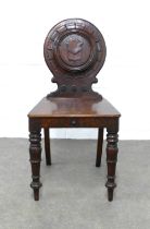 Wylie and Lochhead hall chair, circular back and solid seat, raised on turned legs, stamped 9195,