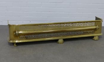 A pierced brass fender, on shell feet, 122 x 27 x 30cm.