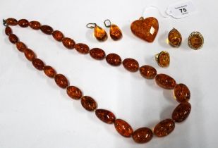 A large heart shaped 14ct gold mounted amber pendant, 14ct gold amber cabochon ring, an amber ring