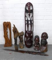 A collection of carved wooden African items to include figures, spears and pierced shield, etc (8)