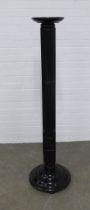 An ebonised torchere stand on square reeded column and circular base, 38 x 145cm.