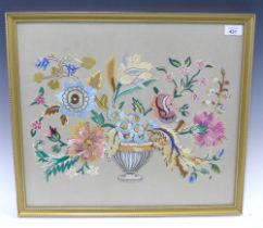 Early 20th century needlework panel of an urn issuing flowers, framed under glass, 53 x 46cm