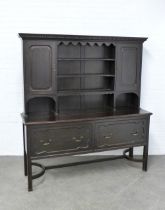 Large oak dresser, cornice top with dentil frieze above a plate rack, flanked by cupboard doors,
