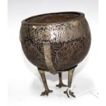 South American white metal mounted and carved coconut cup, raised on three long legs with bird feet,