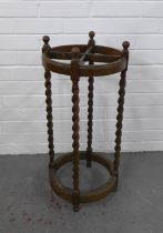 An early 20th century oak stick stand, circular with four divisions and barley twist uprights, 34