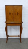 An Art Deco oak and walnut veneered cabinet on a pine base, 72 x 153 x 33cm.