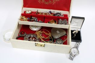 A collection of vintage and later costume jewellery contained within a cream leather jewellery case