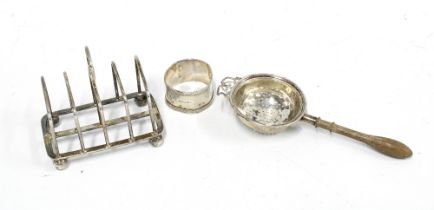 George V silver toast rack London 1914, Birmingham silver tea strainer and a silver napkin ring (3)