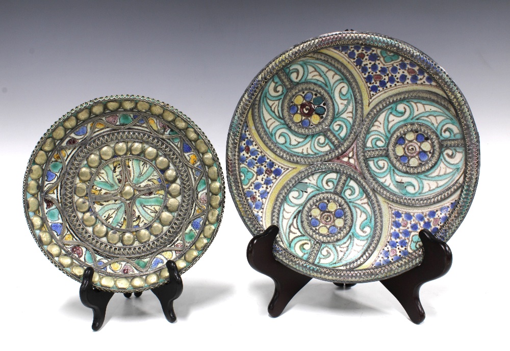 Two Middle Eastern pottery chargers with white metal overlaid borders (2) 26cm.