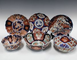 A group of Imari bowls and plates, each typically decorated with chrysanthemums and foliage and with